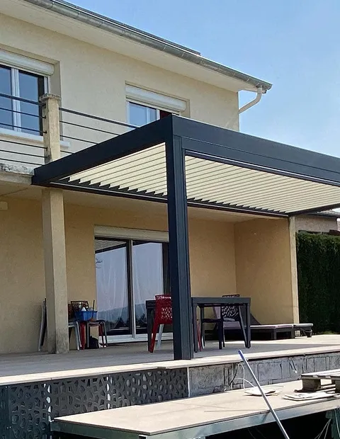 Pergola aluminium noire adossée à une maison.